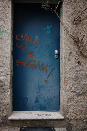 a door in a cement wall with graffiti on it