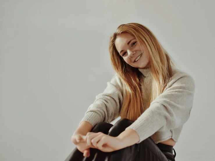 a smiling girl in white shirt sitting down