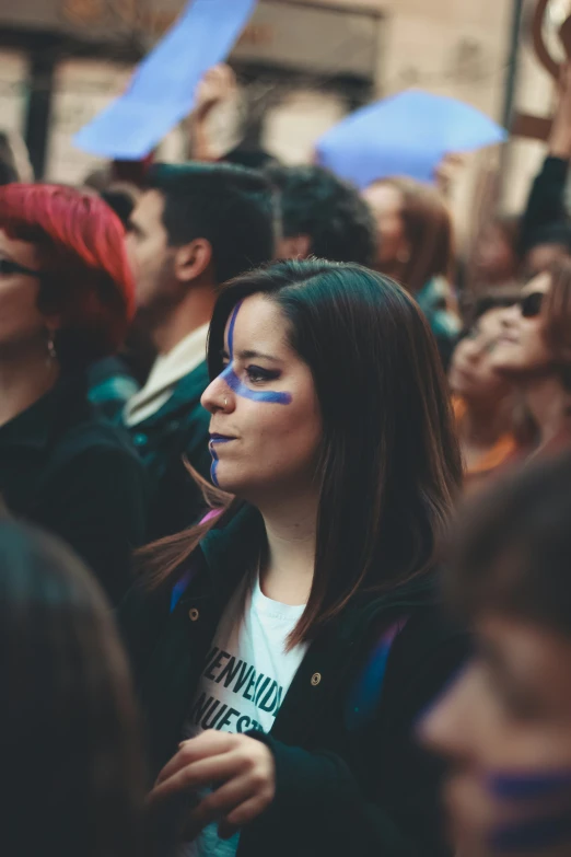 a  with blue makeup in the crowd