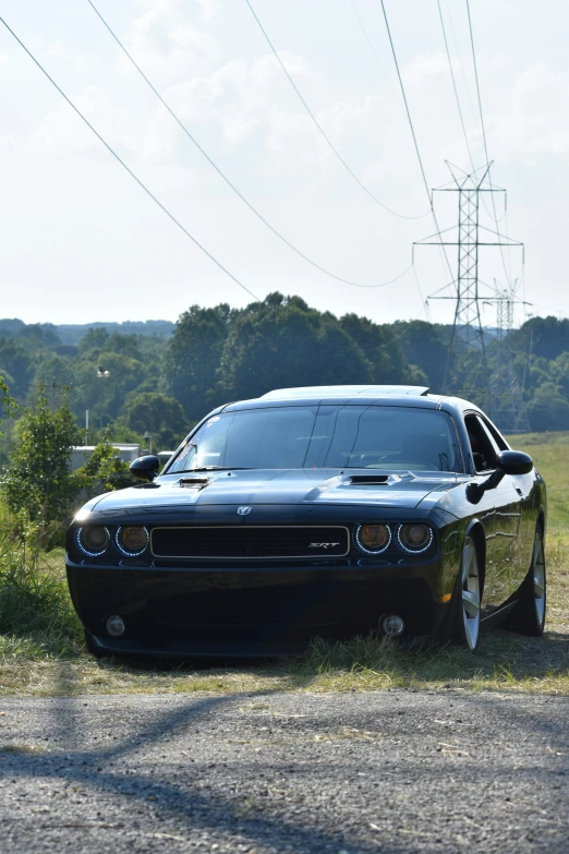 a black sports car is parked near an electric power line