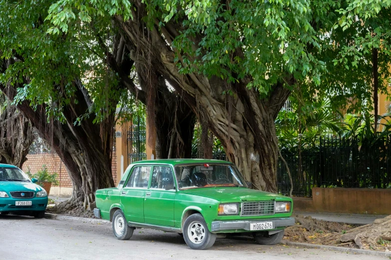 a green truck parked on the side of a road