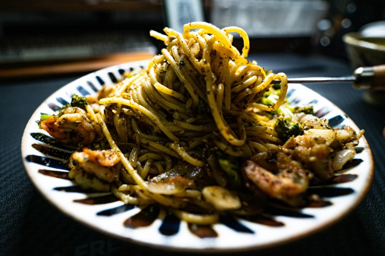 a white plate topped with pasta covered in broccoli