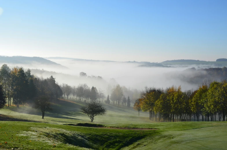 fog hovers on the rolling hills around the golf course