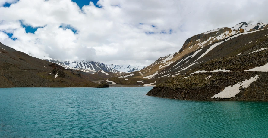 the clouds are covering mountains and a lake