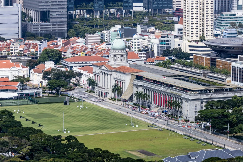 an aerial view of a field with buildings in the background