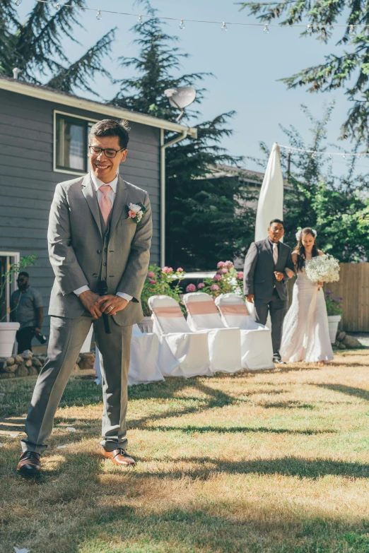 the groom is outside by himself, he is smiling