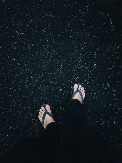 someone has their bare feet in the middle of a black ground