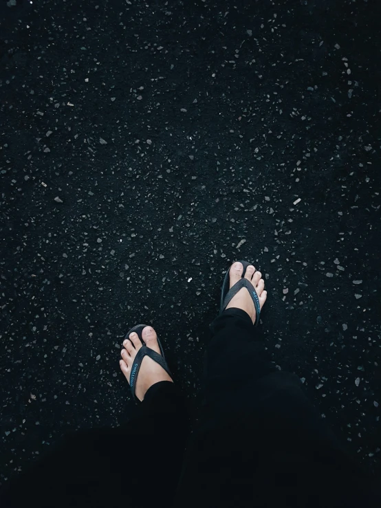 someone has their bare feet in the middle of a black ground