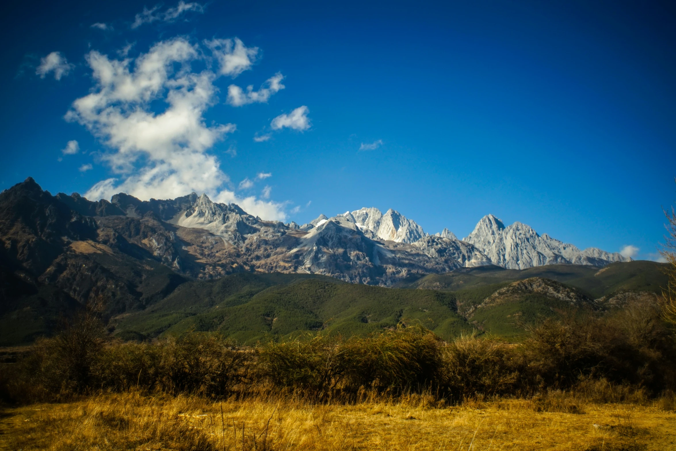 mountains in the background with white clouds in a blue sky