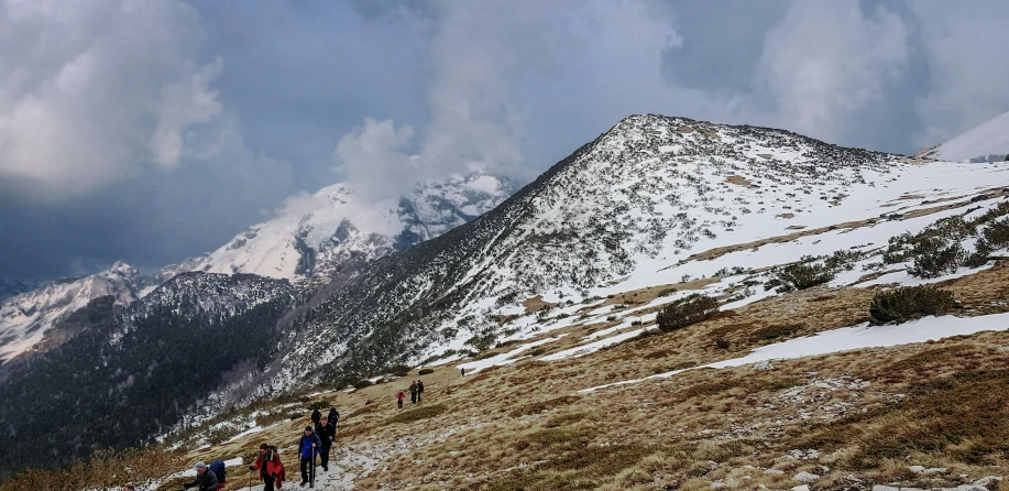 people hiking up the mountain slope to get on the trail