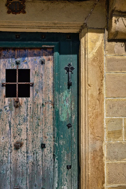 an old, worn and worn green door and wall