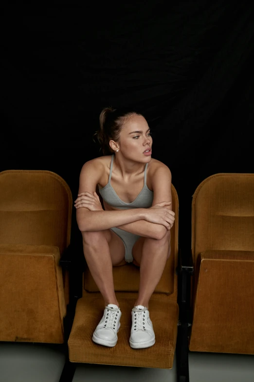 a woman is sitting on an orange chair