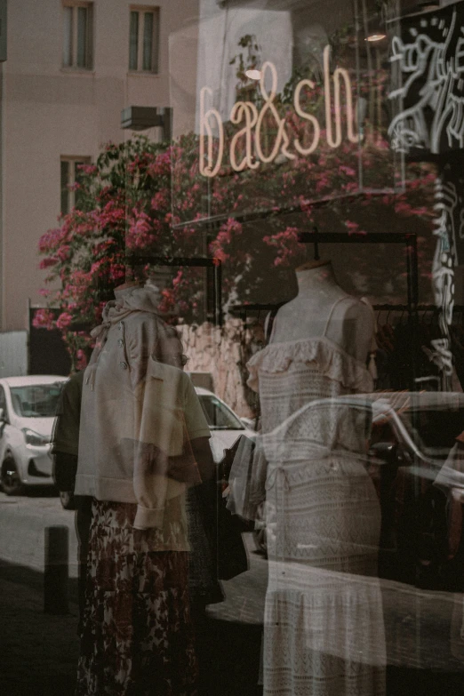 two people wearing long skirts look in the window