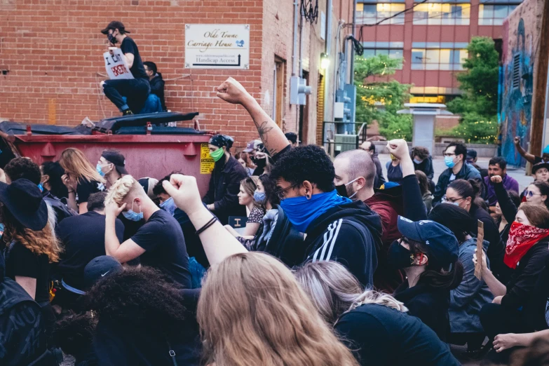 a crowd of people standing in front of a person statue