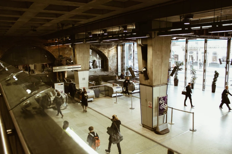 people standing and walking inside a building with glass walls