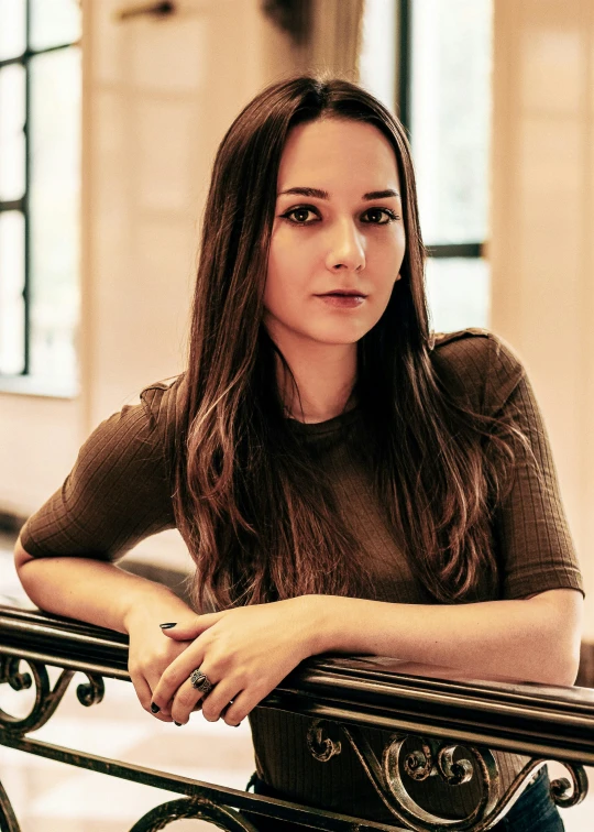 a woman posing on a metal bench in a hallway