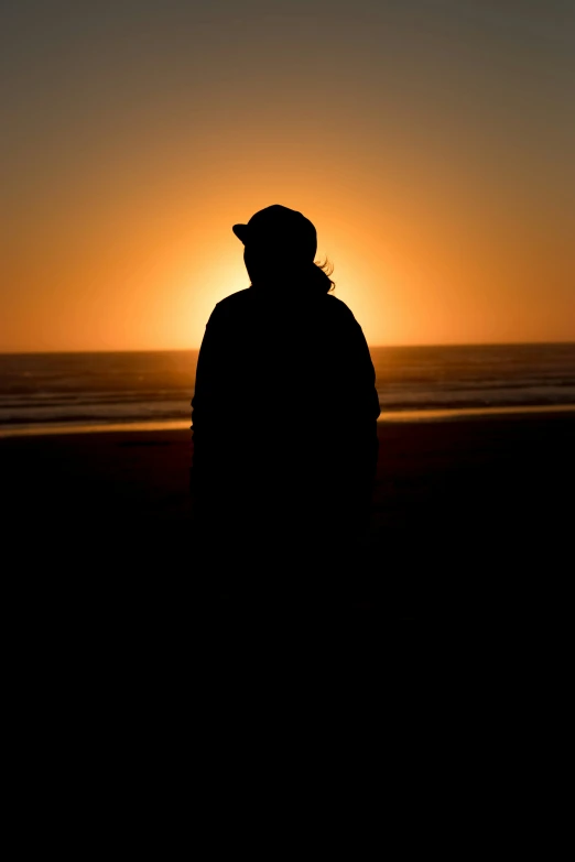 a man on the beach is watching the sun go down