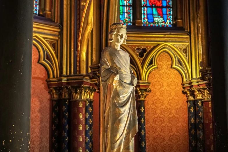 the statue is next to a colorful stained glass window