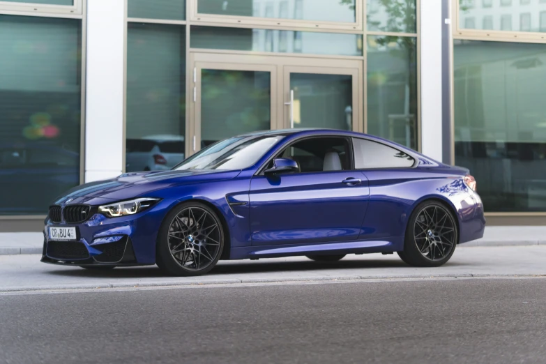 a blue car with large front wheel arches on a city street