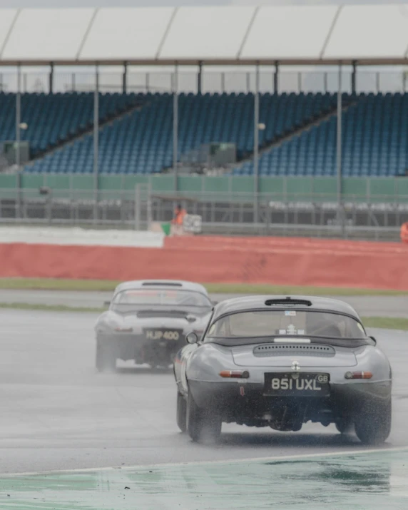 two cars driving on the wet track in the rain