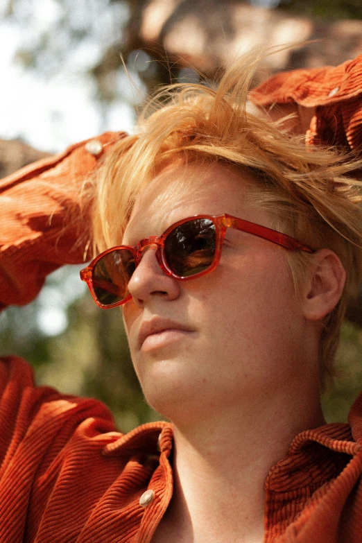 the young woman is posing in her orange shirt