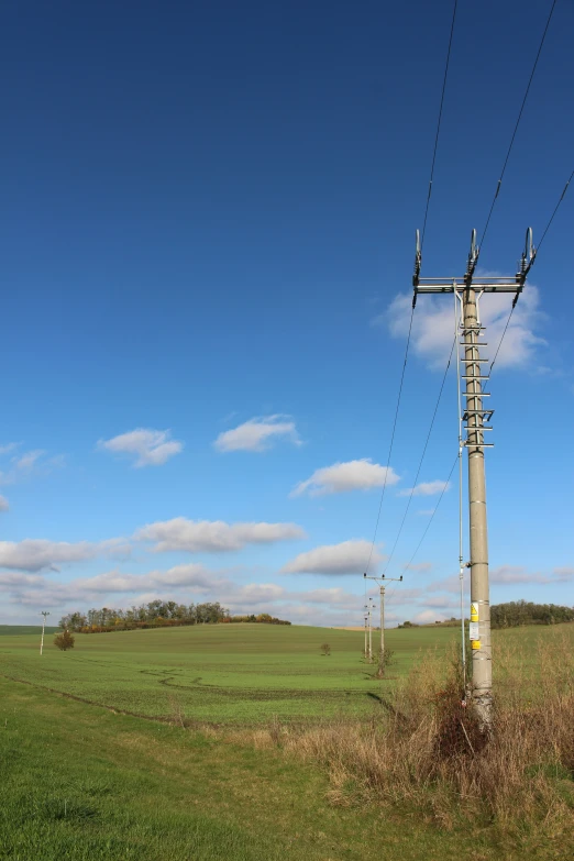 a power line above some grass and a field