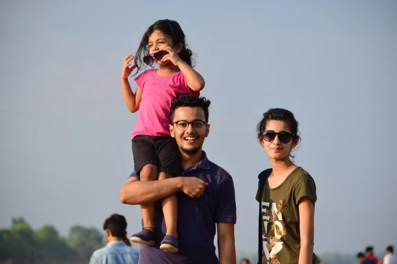 a young child is on top of an adult's shoulders