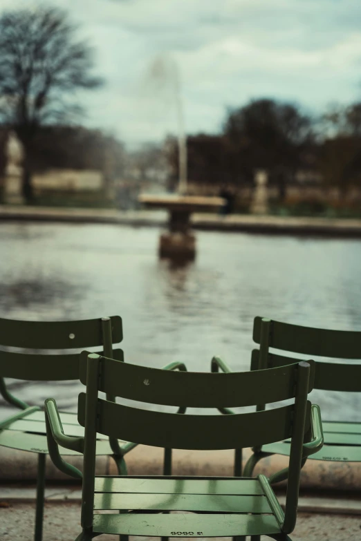 a row of chairs is by the water