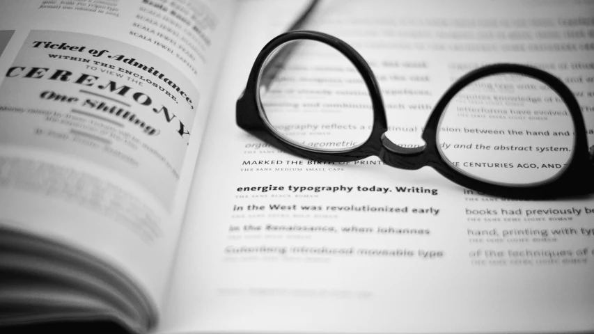 a book with black reading glasses sitting on top of it