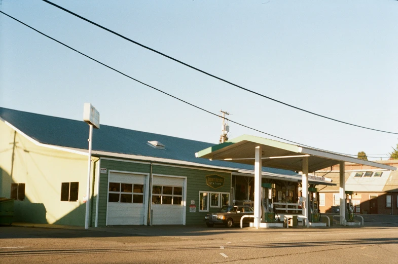 a gas station with two cars parked at the front