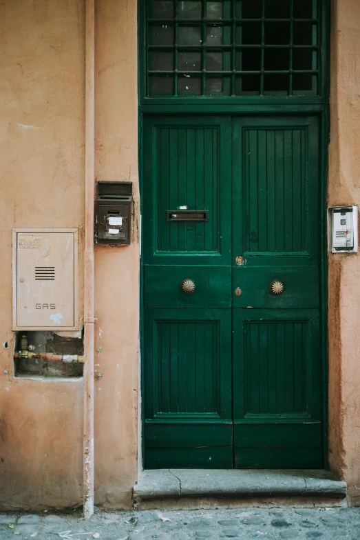 the entrance to a building with green doors