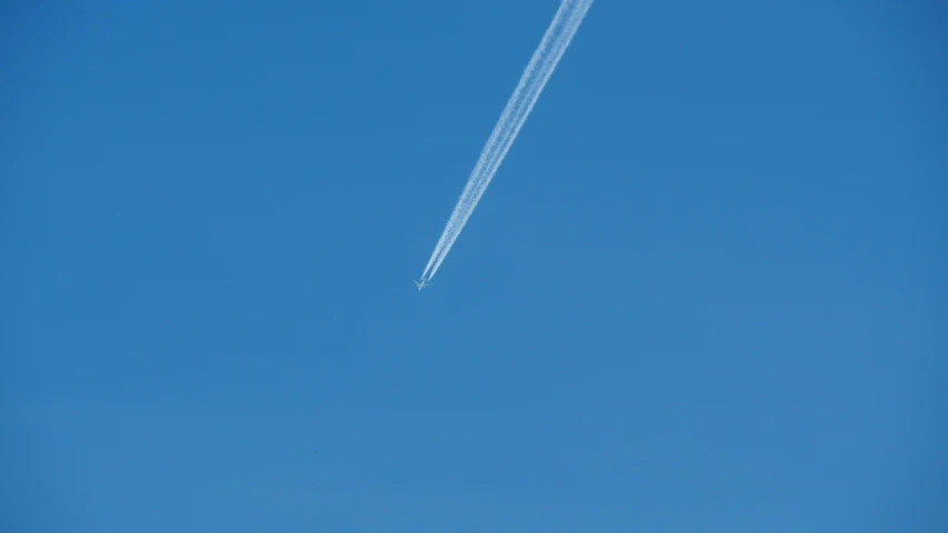 a plane is ascending into the clear blue sky