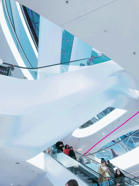 people are riding an escalator in a modern building