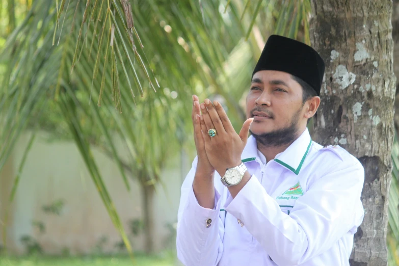 a man sitting in front of a tree praying