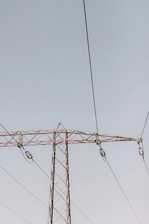 looking up at the top of an electrical pole with many wires below