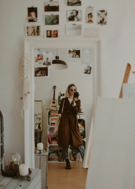 a woman is standing in the mirror in her studio