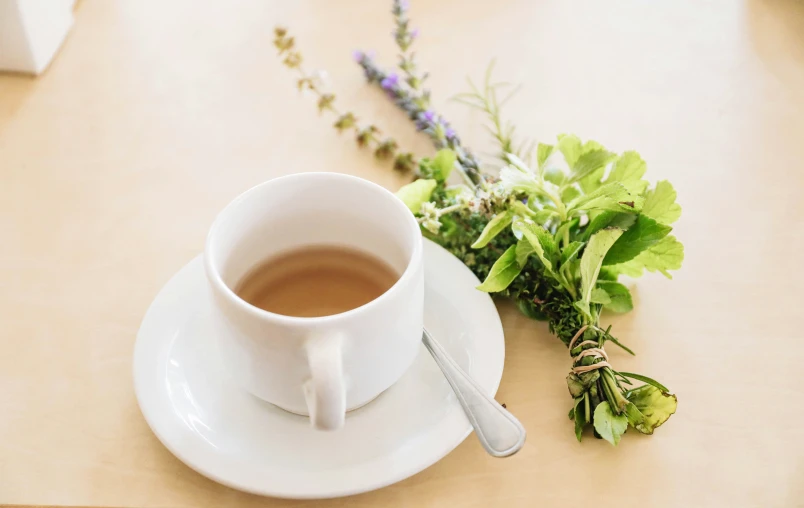 a cup of coffee with a flower on a saucer next to it