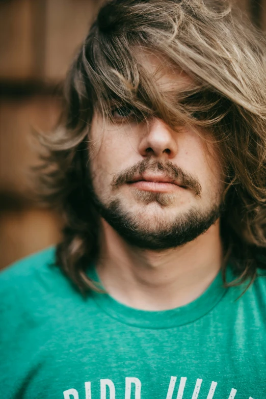 a close up of a young man with long hair