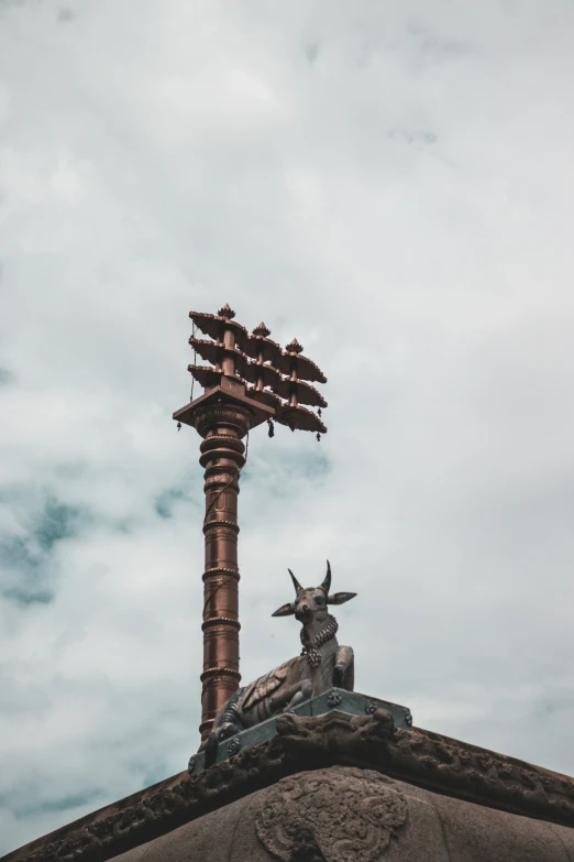 a statue sits on the roof beneath a street lamp