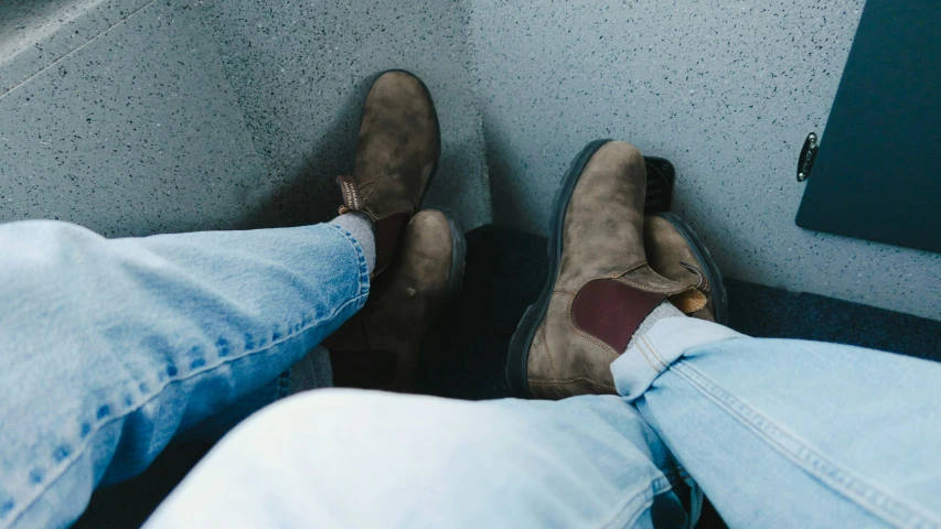 a pair of feet in brown and tan shoes