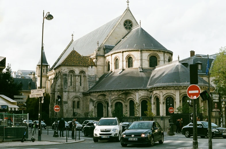 cars are parked on the street in front of this church