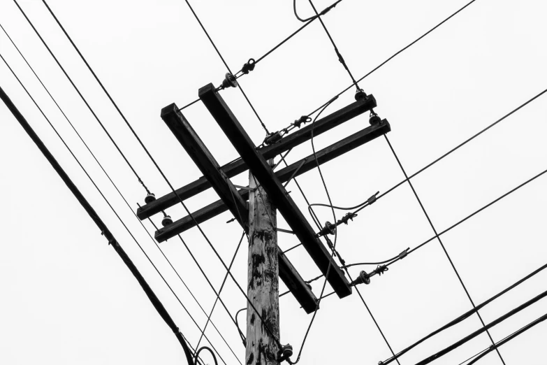 a close - up po of power lines, telephone poles and wires in the sky