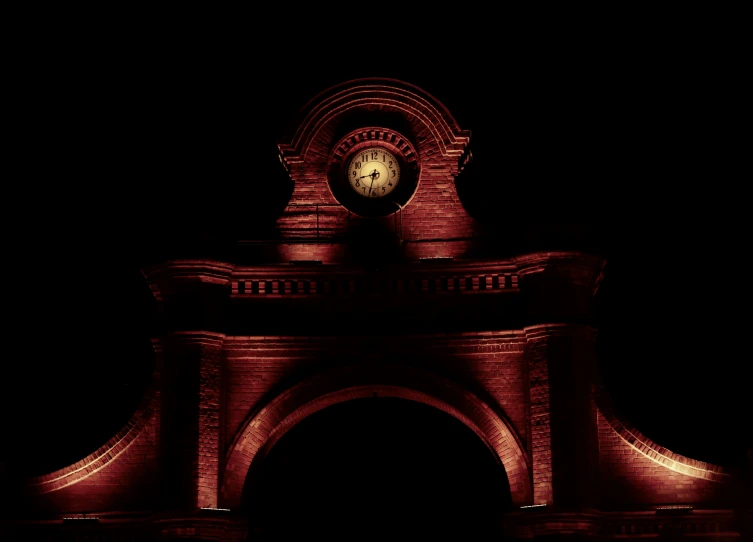 a very bright lit clock at the top of a building