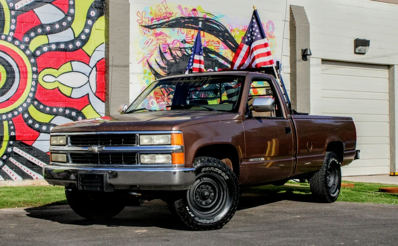 a brown truck parked in front of a painting
