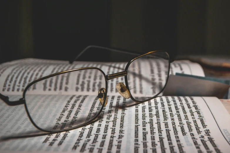 the reading glasses have been placed on an open book