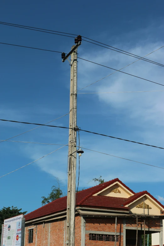 the bird is sitting on the top of the power pole