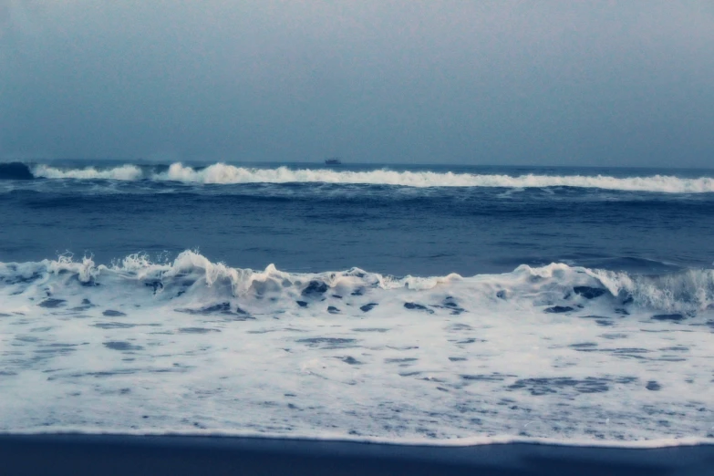 two large waves crashing against each other near the beach