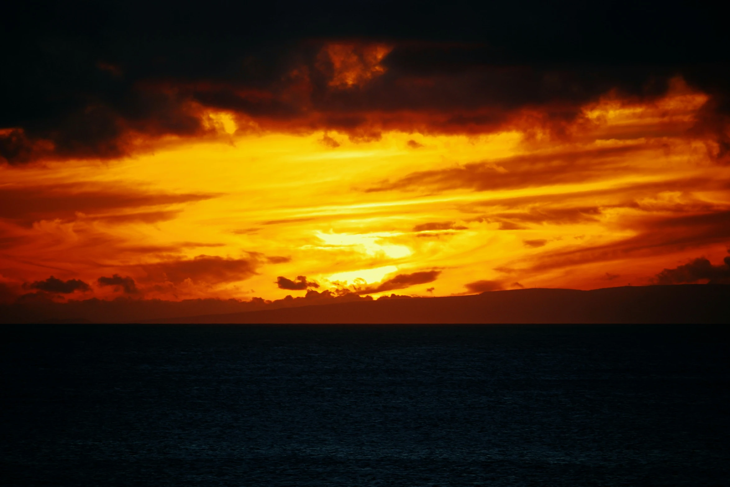 a large body of water sitting under a cloudy sky