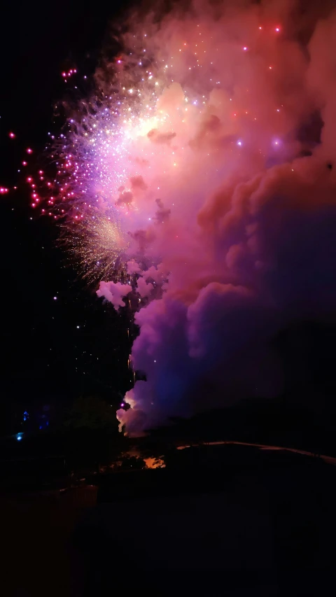 this is fireworks on a dark background and pink, yellow, and orange colors