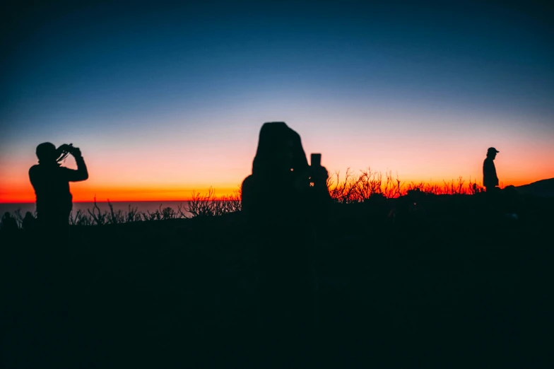 two people with their silhouettes in front of a sunset